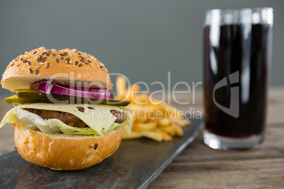 Close up of cheeseburger with french fries and drink