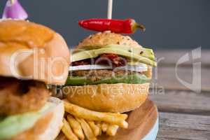 Close up of burger with jalapeno pepper and french fries