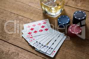 High angle view of cards and chips by whisky