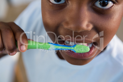 Mid section of boy brushing teeth