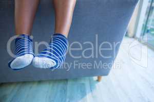 Low section of boy on gray sofa at home