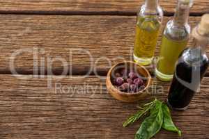 Marinated olives with olive oil and balsamic vinegar bottles on table