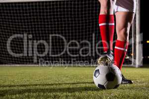 Low section of male soccer player with ball on field