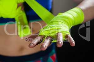 Mid section of woman tying hand wrap on hand