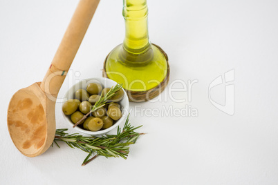 Marinated olives with oil bottle and herb