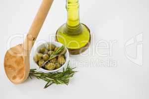 Marinated olives with oil bottle and herb