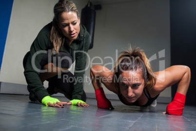 Trainer assisting woman in exercise