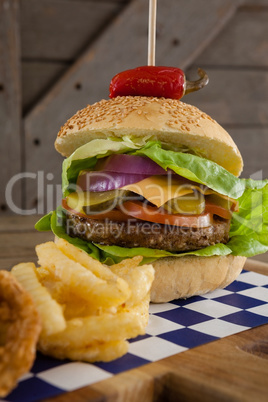 Hamburger and french fries on chopping board