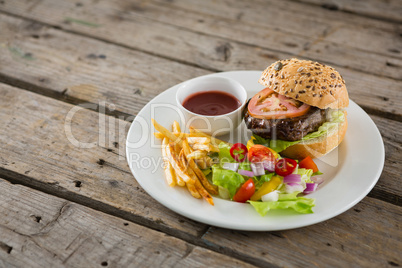 Close up of salad with burger and french fries