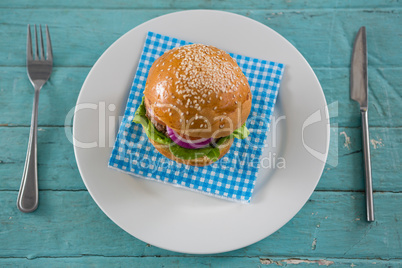Overhead view of burger on napkin in plate