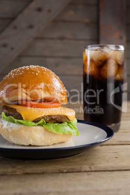 Hamburger in plate with glass of cold drink