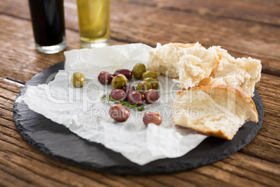 Marinated olives and bread slices kept on tray