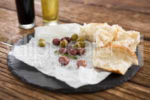 Marinated olives and bread slices kept on tray