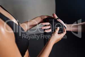 Trainer trying hand wrap on womans hand