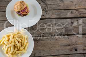 Overhead view of french fries by hamburger served in plate