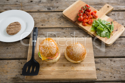 Burgers and vegetables on cutting board
