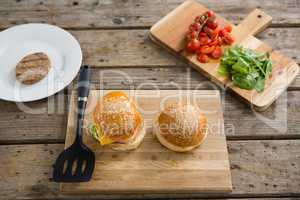 Burgers and vegetables on cutting board