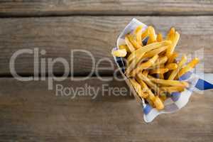 Overhead view of French fries with wax paper in container
