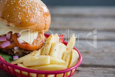 Close up of French fries and cheeseburger in basket