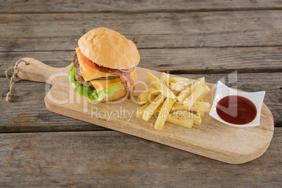 High angle view on burger with French fries and sauce