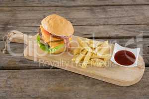 High angle view on burger with French fries and sauce