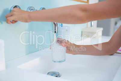 Cropped image hands taking water in drinking glass