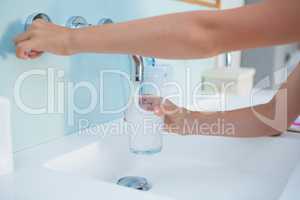 Cropped image hands taking water in drinking glass