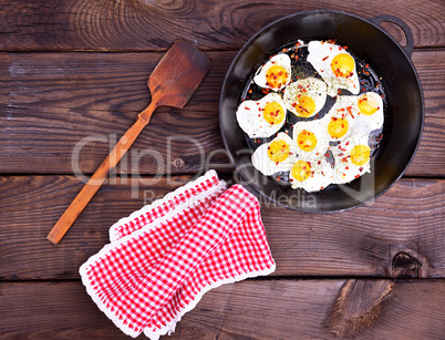 Fried quail eggs in a black frying pan