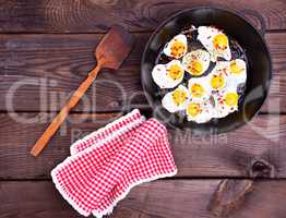 Fried quail eggs in a black frying pan
