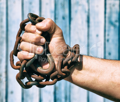 man's right hand is wrapped in an iron chain