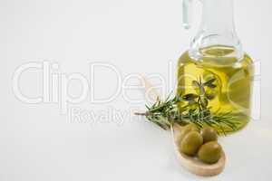 Marinated olives with oil bottle and herb