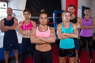 Portrait of confident young athletes standing with arms crossed