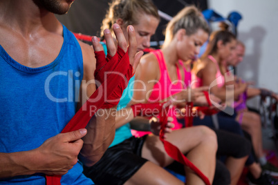 Row of athletes wrapping bandages on hands