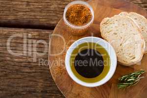 Olive oil with bread and spice powder on table