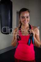 Portrait of fit woman standing with skipping rope