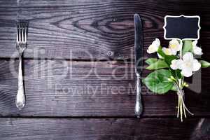 Iron fork and knife with a bouquet of jasmine