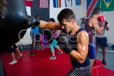 Young male boxer punching bag