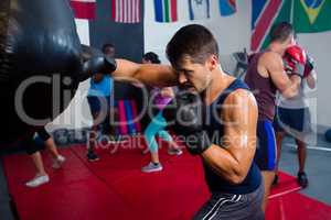 Young male boxer punching bag