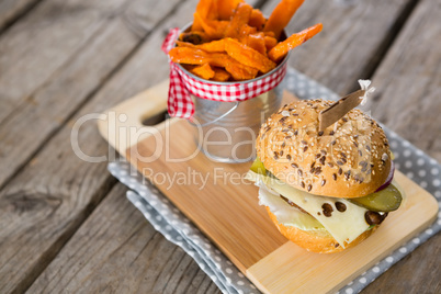 Close up of french fries in container by cheeseburger