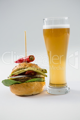 Close up of hamburger with jalapeno by beer glass