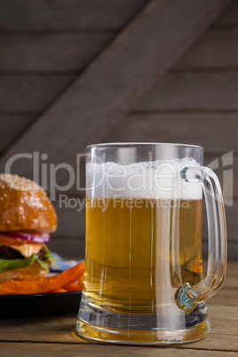 Burger and french fries in plate with glass of beer