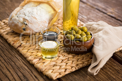 Marinated olives, oil bottle and salt on chopping board