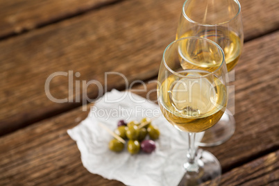 Close-up of olives with glasses of wine