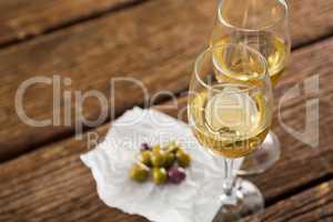 Close-up of olives with glasses of wine