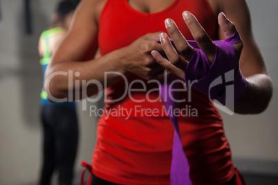 Mid section of woman tying hand wrap on hand