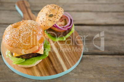 High angle view of burger on wooden cutting board