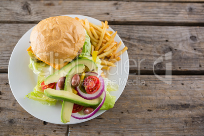 Overhead view of cheeseburger with salad and french fries