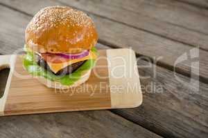 Hamburger with cheese on cutting board