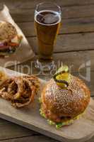 Hamburger and onion ring with glass of beer
