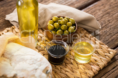 Marinated olives and oil bottle on wooden table